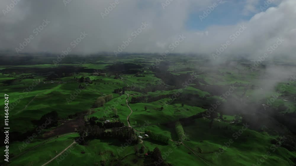 Drone flight through the clouds revealing a beautiful green pasture field. Drone flight through the clouds revealing a beautiful green pasture field.
