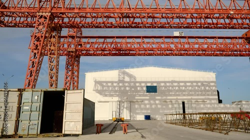 Outdoor warehouse at construction site time-lapse. Construction site depot with hangar and gantry crane timelapse