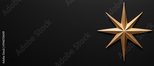 A striking golden star against a sleek black background for design and decor. photo