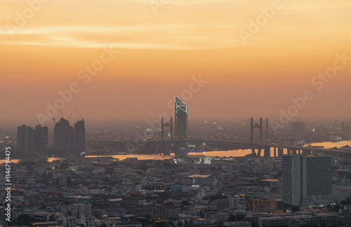 Obraz na płótnie Cityscape of Bangkok with Thotsamarachan Bridge (Rama IX Bridge) crossing Chao phraya river with Dramatic orange sky background in the sundown. use it as your Wallpaper, Poster and Space for text, w salonie