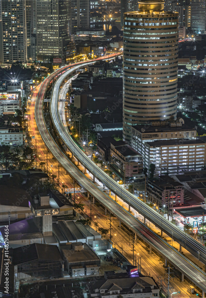Night scene of light trails of cars on the road of Bangkok city. Nightscape view of with bright glowing lights after sunset, Long exposure for Light curve lines, use it as your Wallpaper, Poster.