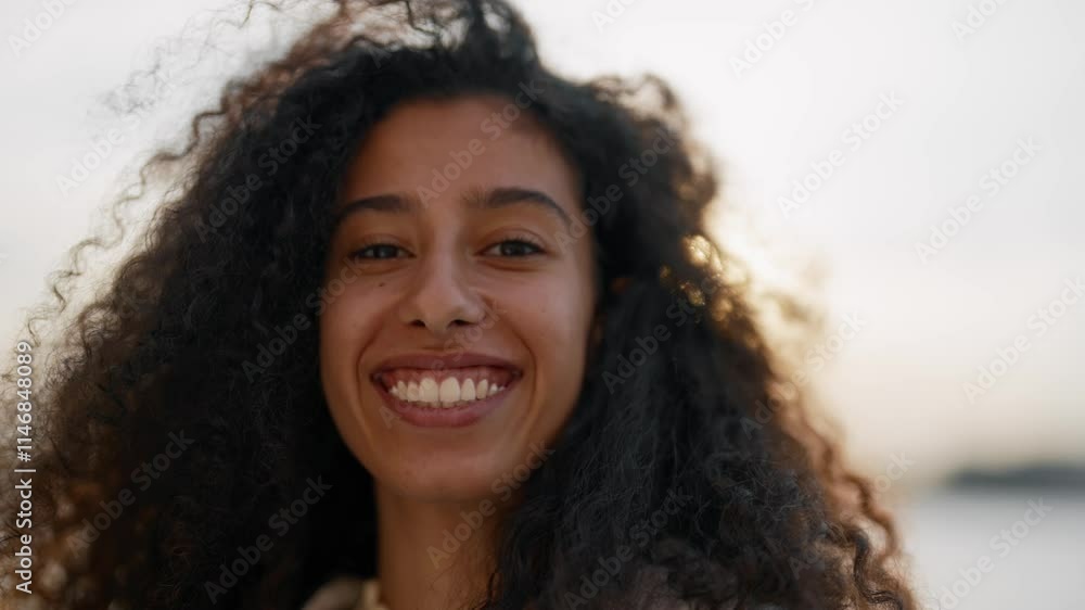 Attractive young Arab woman playing with hair in wind, smiling kindly, portrait . Joyful female face, natural beauty, mixed race girl in city embankment, medium shot, slow motion, happy townswoman Attractive young Arab woman playing with hair in wind, smiling kindly, portrait . Joyful female face, natural beauty, mixed race girl in city embankment, medium shot, slow motion, happy townswoman