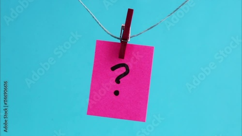 Clothesstick holding fuchsia note with question mark