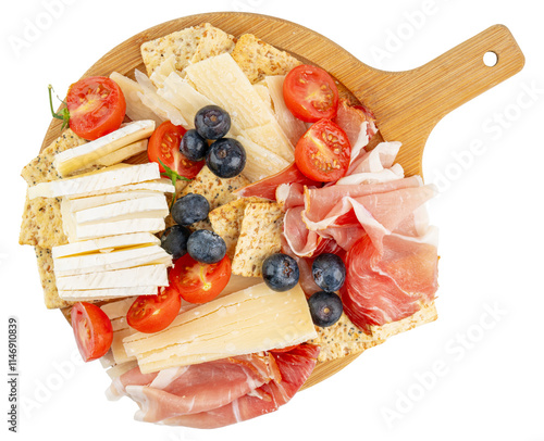 Charcuterie board. Wooden cutting board. Fruit and cheese platter. Cherry tomatoes and blueberries. Brie and parmesan cheese. Crackers and prosciutto. Sliced cheese and deli meat gourmet party snack. 