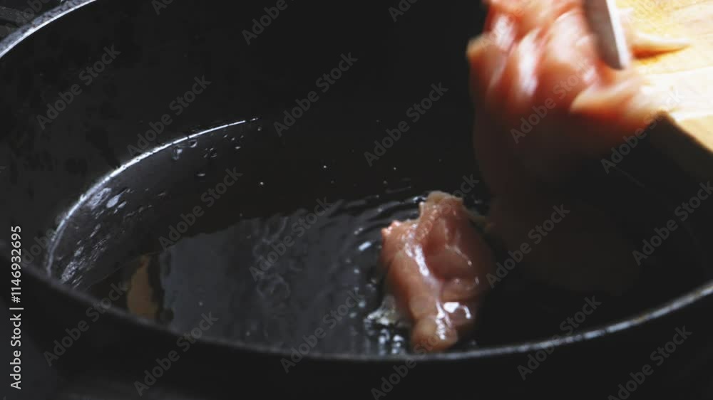 Chicken fillet falls into a frying pan with boiling oil. Close-up Chicken fillet falls into a frying pan with boiling oil. Close-up