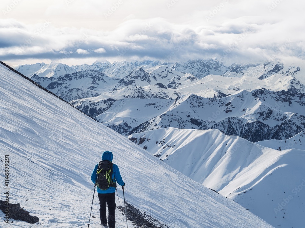 Hiker trekking in snowy mountain landscape Hiker trekking in snowy mountain landscape