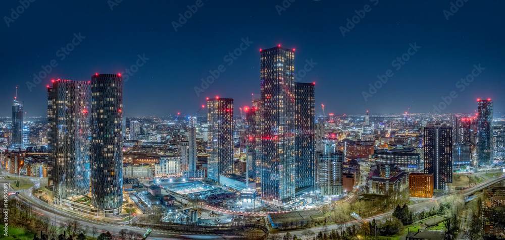 Fototapeta premium Manchester City Centre Aerial View at Night. Illuminated Skyline and Urban Architecture create vibrant England cityscape.