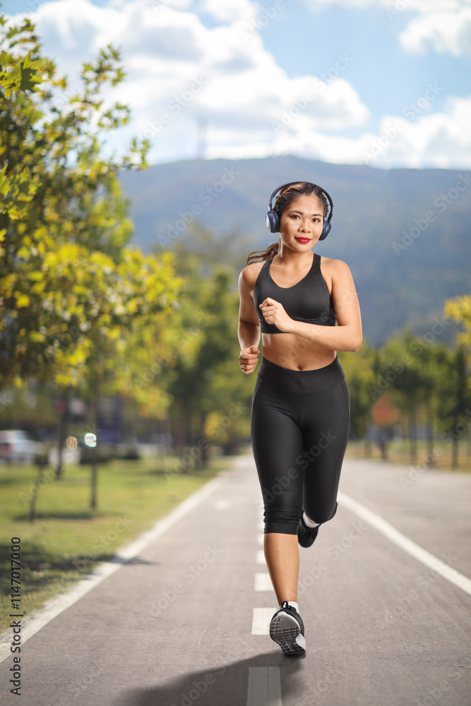 Young asian woman jogging with headphones Young asian woman jogging with headphones