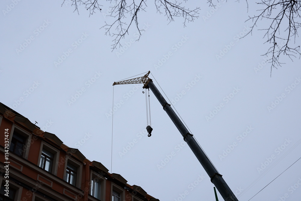 A Construction Crane is Actively Working Near a Building in an Urban Setting Today