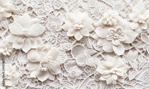 White fabric flowers on delicate lace background.