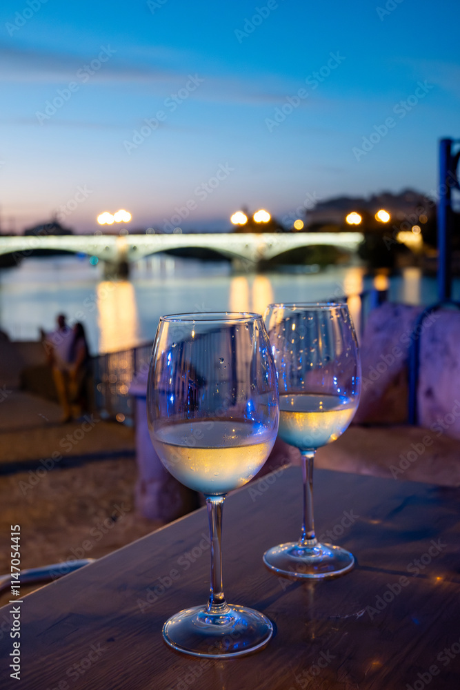Two glasses of cold dry white wine served outdoor in cafe at night in historical Triana district, Sevilla, Spain, close up Two glasses of cold dry white wine served outdoor in cafe at night in historical Triana district, Sevilla, Spain, close up