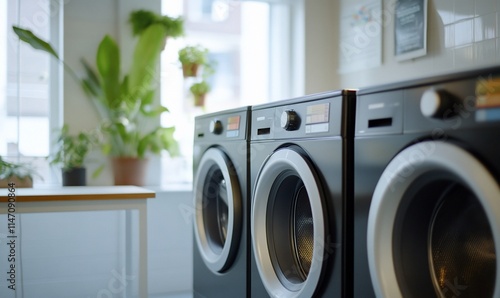 A modern laundry room featuring sleek washing machines and plants. photo