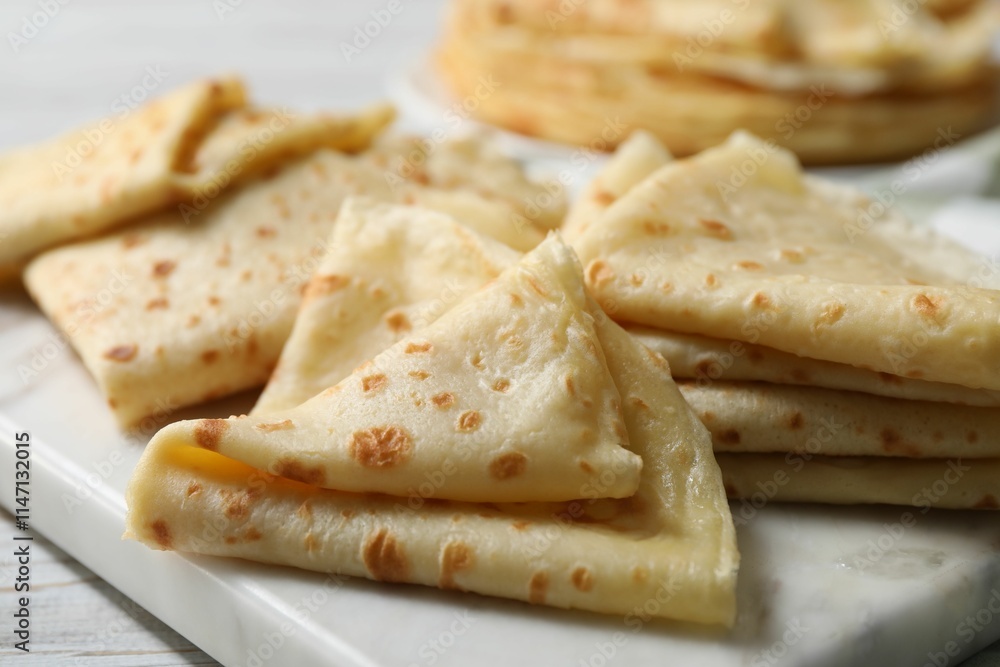 Many tasty crepes on white wooden table, closeup Many tasty crepes on white wooden table, closeup