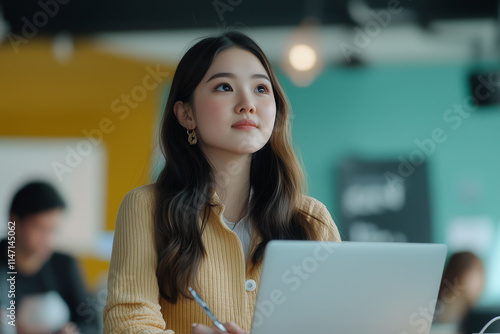 Young woman working on a visual presentation in a modern workspace during daylight hours photo