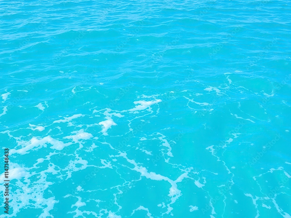 Obraz premium Pure blue turquoise water with foam from waves creating a textured ocean surface, tranquil, sea, peaceful