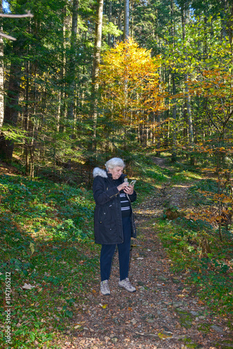 Woman taking a hike in autumn forest of Skhidnytsia, Ukraine.