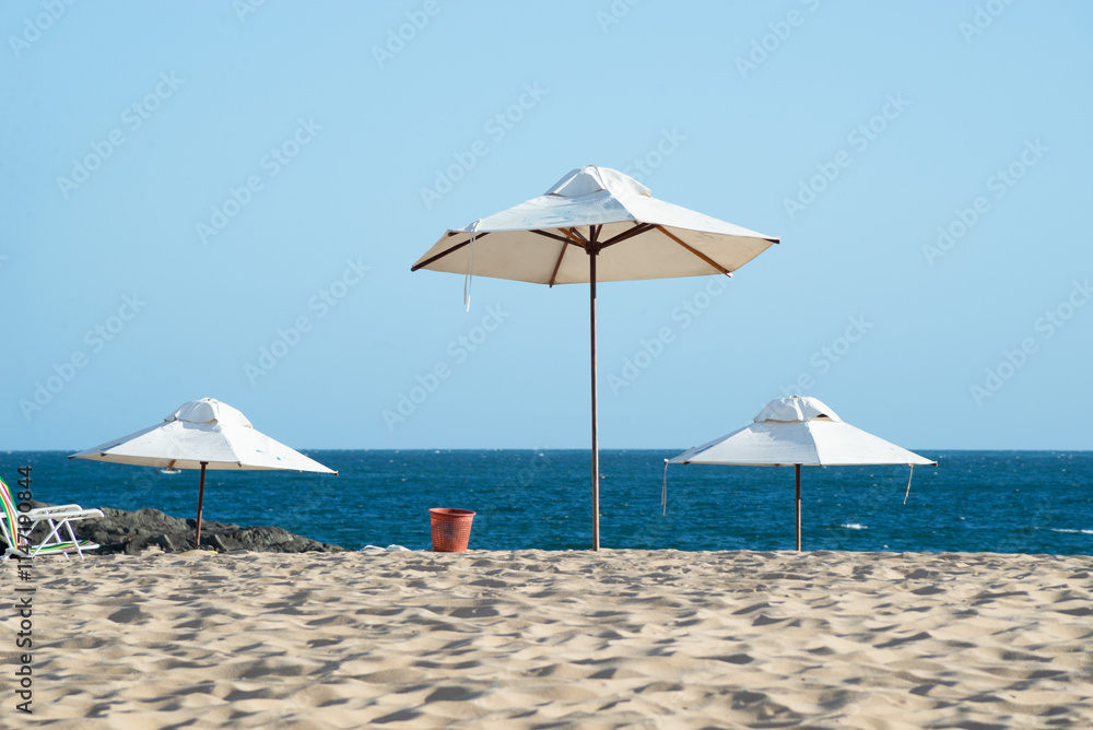 Umbrellas on the beach with blue sky and sea in the background. Vacation concept.