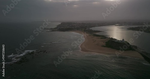 Newcastle Harbour at Nobby's Beach lighthouse during sunset after storm 