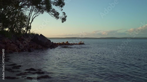 Pelican's looking at sunset in Nelson Bay in Australia while cormorant dries it's wings