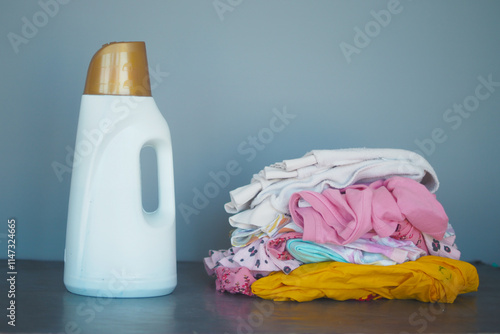 Laundry Essentials A Pile of Colorful Clothes Waiting with Detergent Close By photo