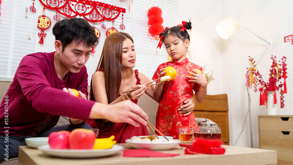 A Chinese family of three arranges a festive dining table to celebrate ...