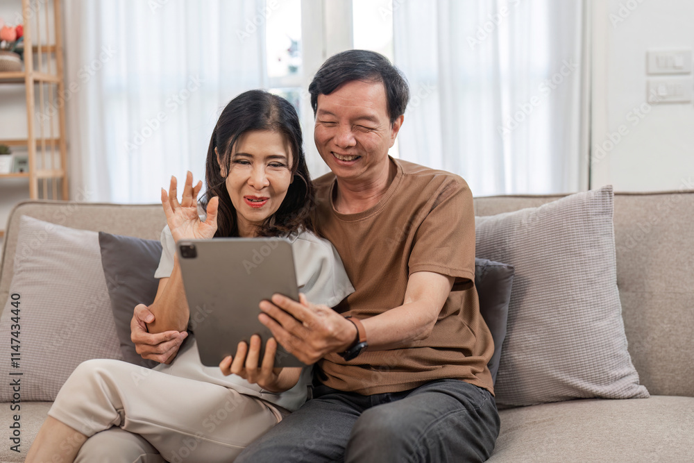 Retired Couple Enjoying a Video Chat with Their Children on a Tablet in a Cozy Living Room Setting Retired Couple Enjoying a Video Chat with Their Children on a Tablet in a Cozy Living Room Setting
