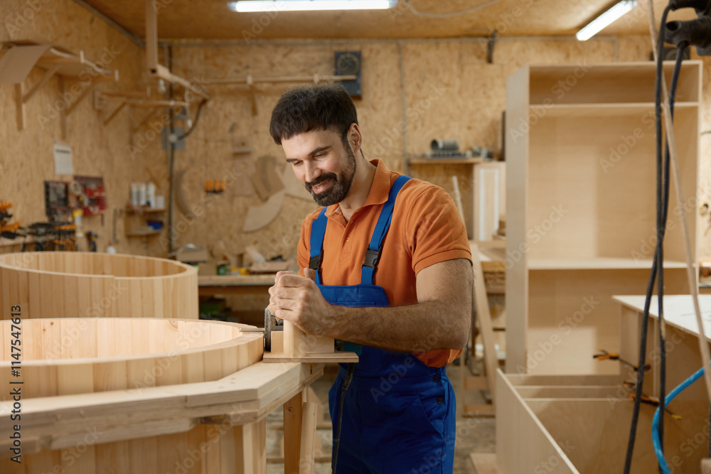 Carpenter working on mini home wooden phytobarrel sauna at workshop Carpenter working on mini home wooden phytobarrel sauna at workshop