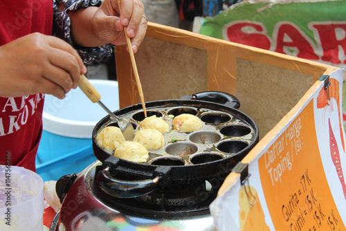 Fototapeta Naklejka Na Ścianę i Meble -  Street vendor cooking and selling takoyaki, Japanese food