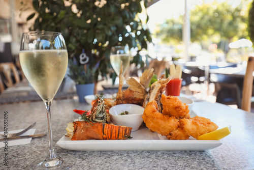 Seafood platter in alfresco dining setting featuring squid, prawns and barramundi wings photo