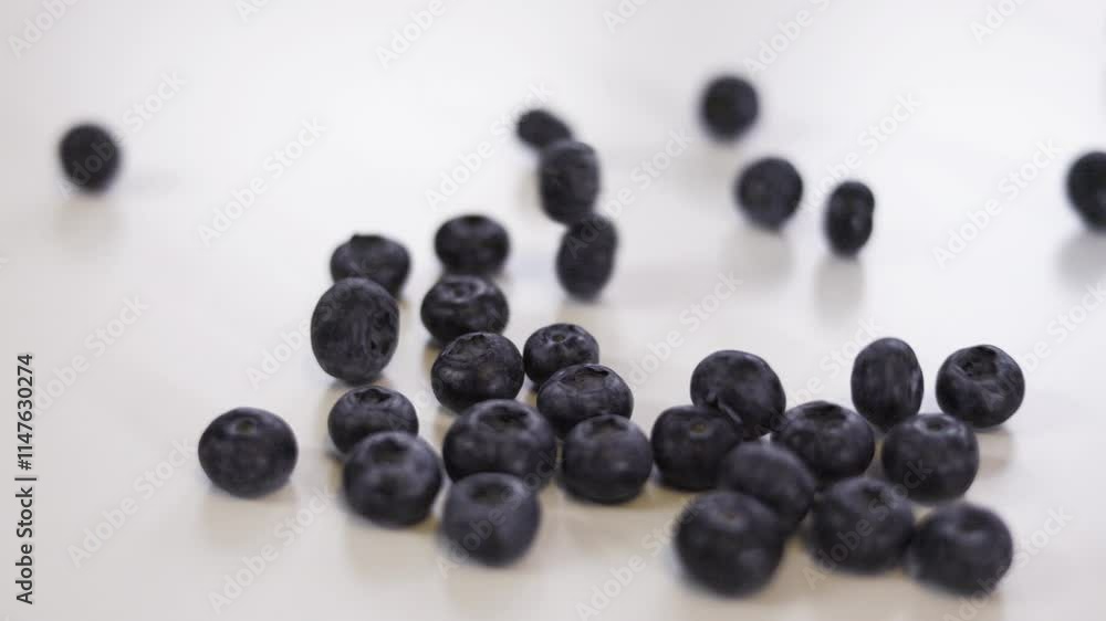 Rolling blueberries isolated on white background. Delicious blueberries falling on a white table. Rolling blueberries isolated on white background. Delicious blueberries falling on a white table.
