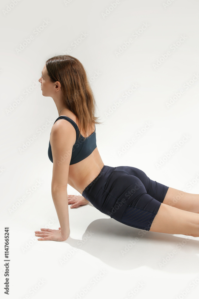 Young woman practicing stretching yoga positions, wellbeing and self care concept Young woman practicing stretching yoga positions, wellbeing and self care concept