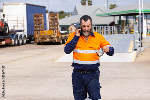 happy working man walking while answering phone on the worksite. photo