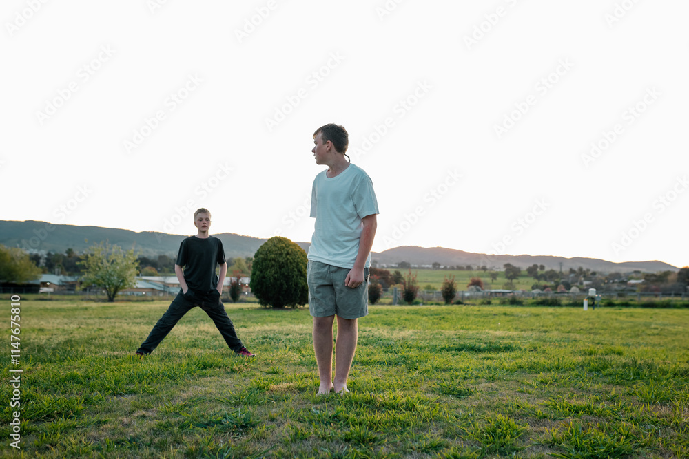 Boys enjoying afternoon in a green field surrounded by hills in the countryside Boys enjoying afternoon in a green field surrounded by hills in the countryside