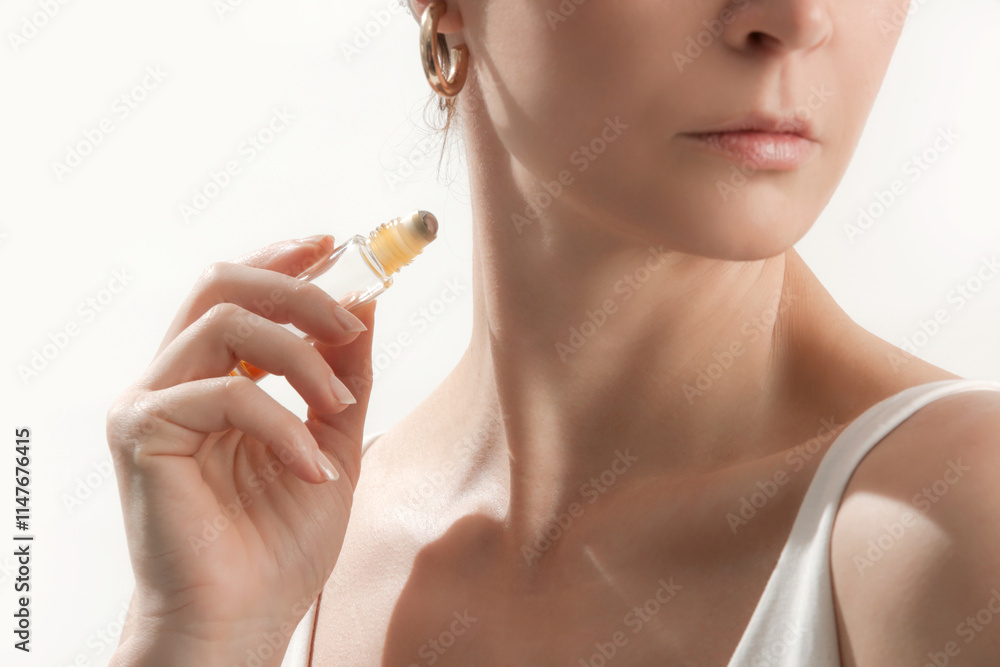 Studio shot of woman applying healing essential oil roller blend. Organic aromatherapy scent, all natural perfume oil. Homeopathic self care.	