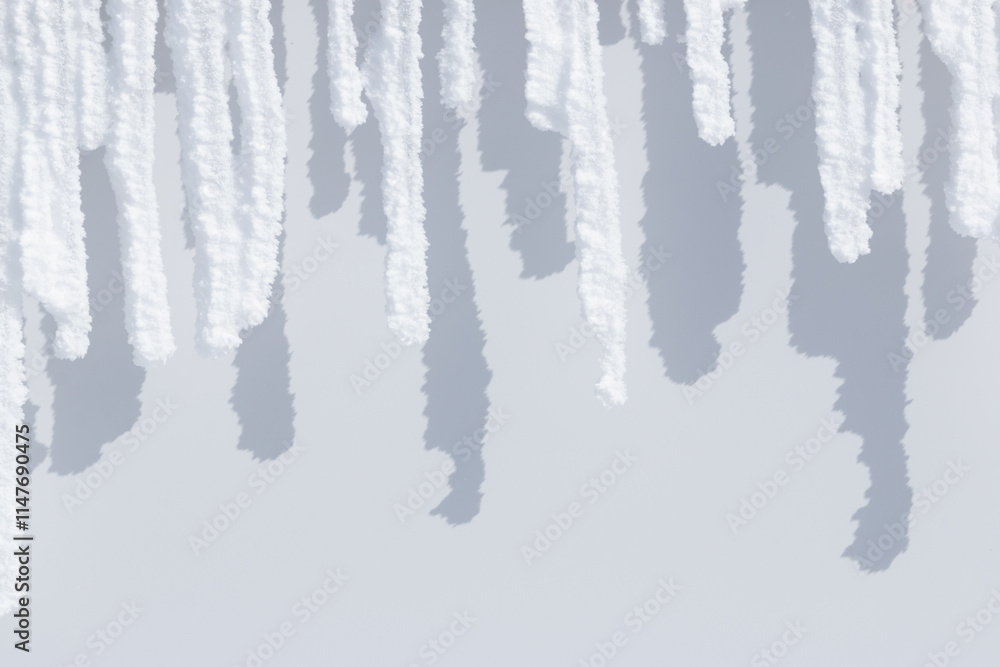 Row of white sunlit snow icicles and shadows Row of white sunlit snow icicles and shadows