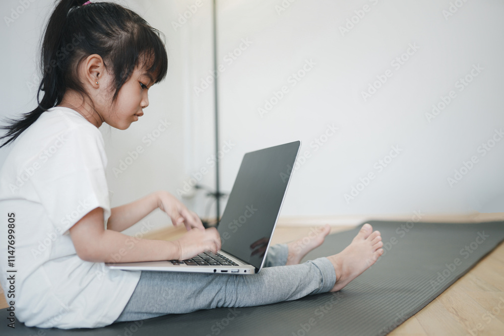 Cheerful girl doing yoga at home, looking at laptop screen
Cheerful girl doing yoga at home, looking at laptop screen