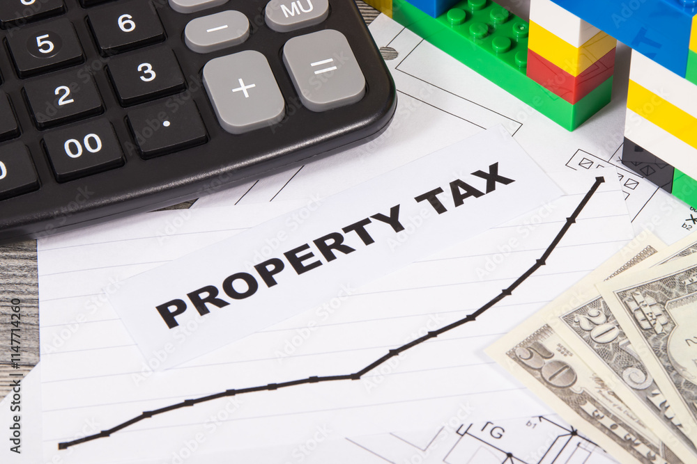 House made of toy blocks, calculator, dollar banknotes and rising graph showing property tax increases. Calculating and paying tax House made of toy blocks, calculator, dollar banknotes and rising graph showing property tax increases. Calculating and paying tax