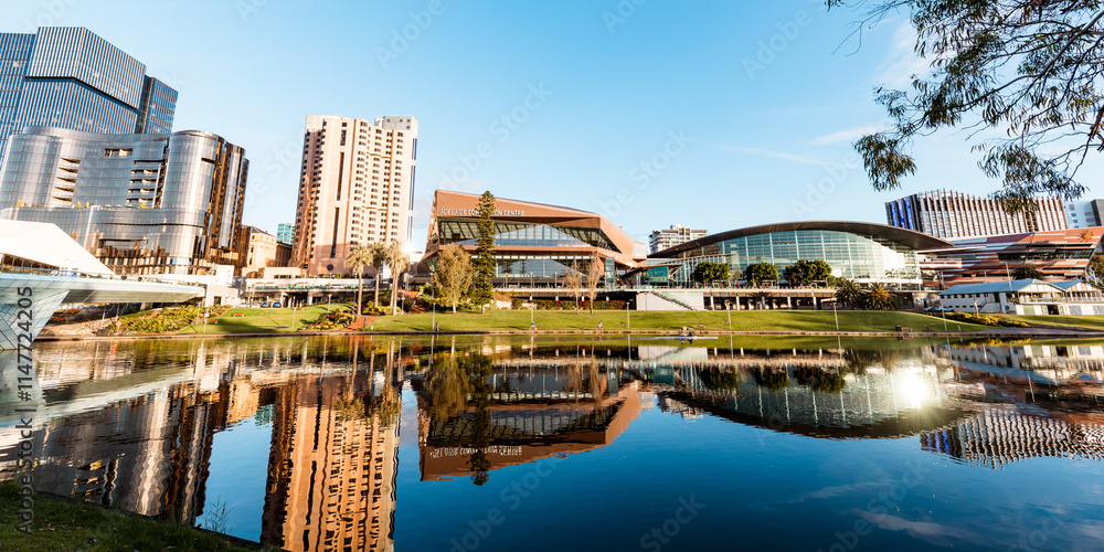 View of Adelaide city across the Torrens River with buildings reflected in water View of Adelaide city across the Torrens River with buildings reflected in water