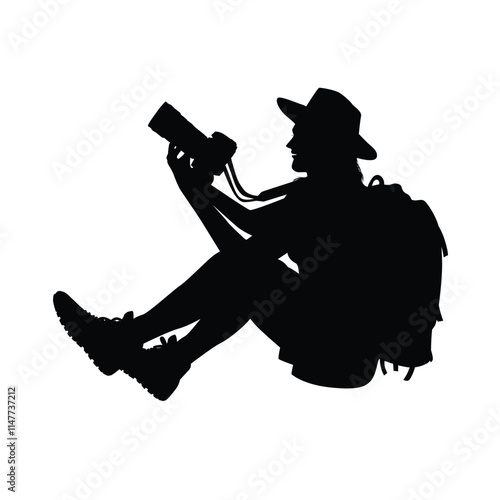 Silhouette of a female backpacker using a photo camera