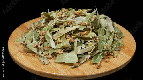 Close-up image of dried linden flowers on black background.