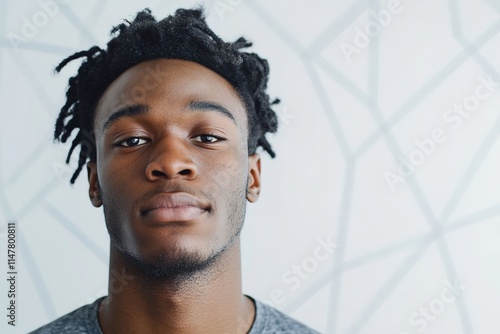 Confident young man with unique hairstyle poses against modern g photo