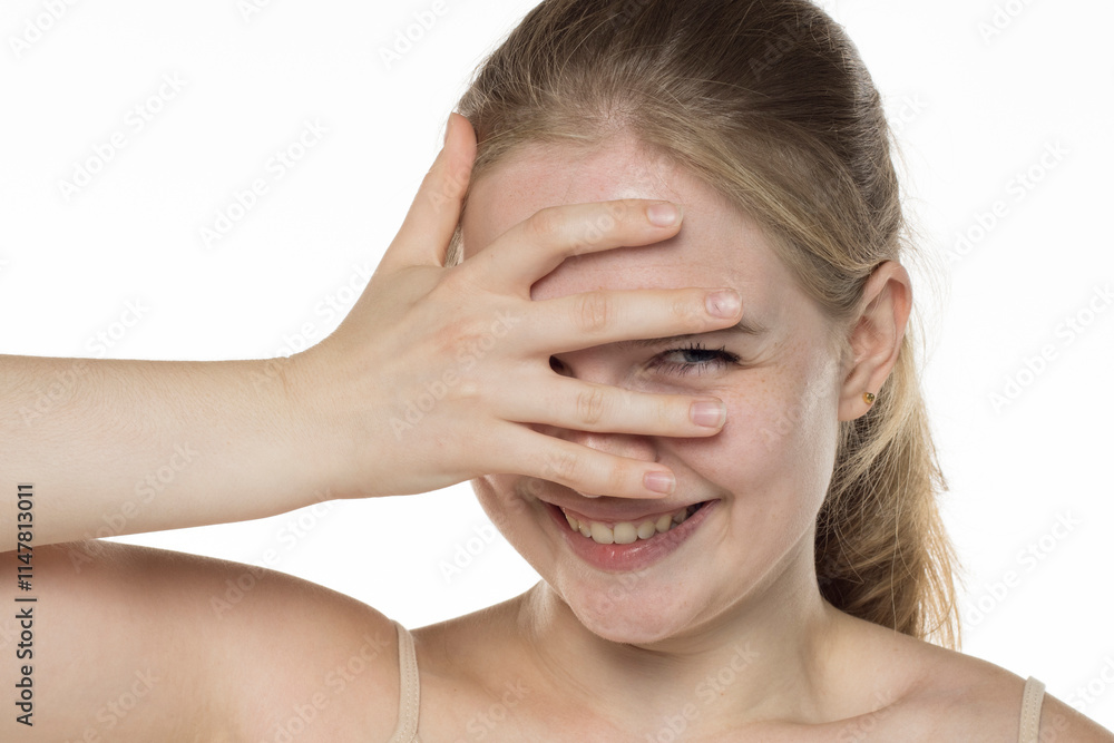 Young happy blonde woman peeking out from between her fingers. Young happy blonde woman peeking out from between her fingers.