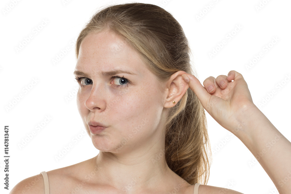 Portrait of a young blonde woman pulling her ear on a white background. Portrait of a young blonde woman pulling her ear on a white background.