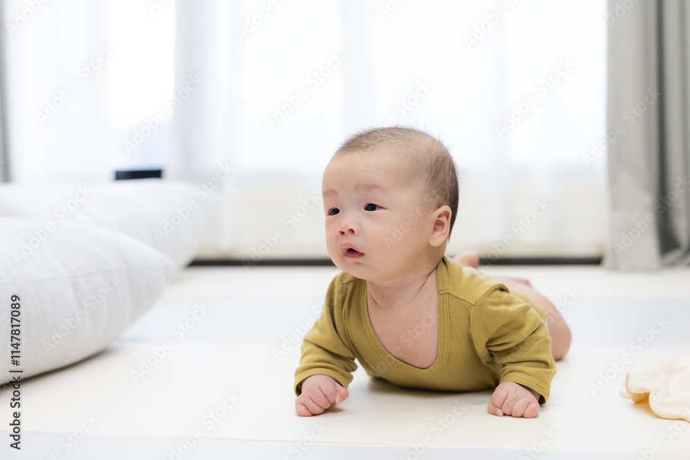 Baby on play mat lying down indoors Baby on play mat lying down indoors