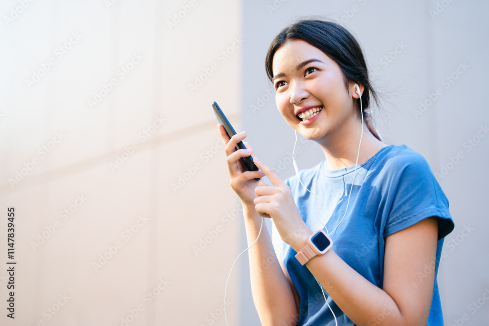Happy relaxed woman in earphones or headphone choosing, listening favorite music from mobile phone in urban city sunny street. Travel, tourism, technology, blogging concept. Happy relaxed woman in earphones or headphone choosing, listening favorite music from mobile phone in urban city sunny street. Travel, tourism, technology, blogging concept.