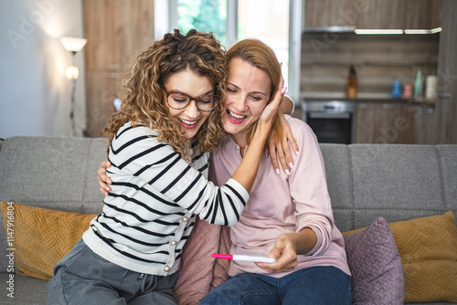 Two female friends are excited about the results of a pregnancy test photo