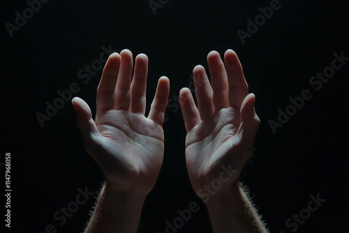 two hands extends an open palm on a black background, studio light.