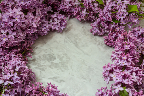 Spring feminine scene, floral composition. Decorative banner, corner made of beautiful purple lilac flowers. White table background.