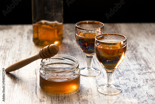Foto Still life close-up of two glasses of honey mead (medovukha) with honey dipper o