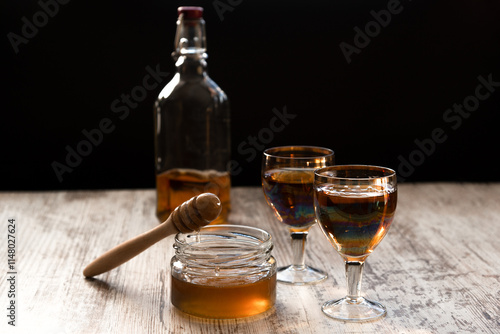 Foto Still life close-up of two glasses of honey mead (medovukha) with honey dipper o